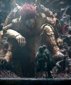 A gigantic hulking warrior sits before two cowering humans in A Writer’s Odyssey.